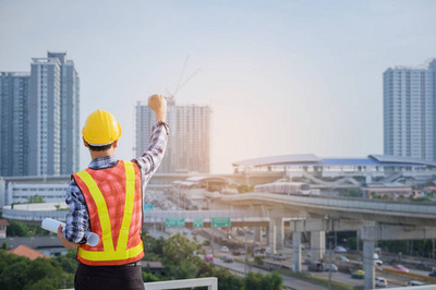 工程師或建筑師與防護安全帽檢查建筑圖紙呼叫支持團隊在建筑工地。工程建筑和建筑施工理念。軟焦點